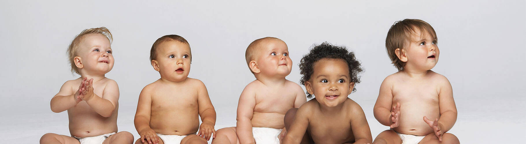 Diverse babies sitting in a row