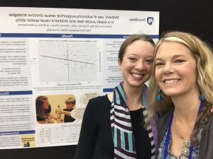 Catherine Hamby and Dr. Erika Lunkenheimer standing next to a research poster.