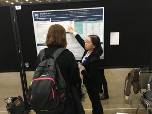 Yangyang Wang explaining their 2019 SRCD poster to a passerby.