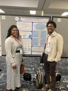 Dr. Dawn Witherspoon and Myles Arrington standing next to research poster