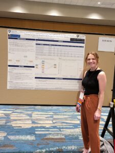 Madison R. Kelm standing next to research poster