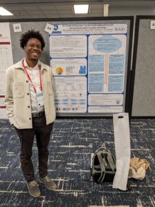 Myles Arrington standing next to research poster
