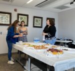 Three graduate students talking at reception