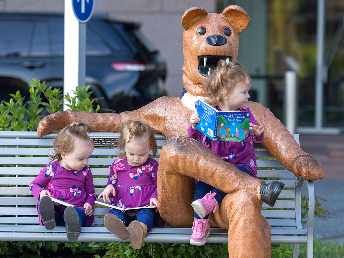 Nittany lion sitting with three children