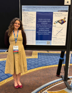 Alexandra Petryezenko standing next to 2025 ADAA conference poster