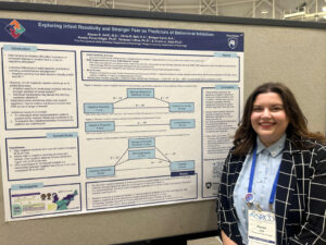 Alyssa Swift standing with 2025 SRCD poster