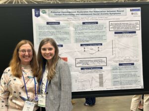 Kristin Buss and Maddie Politte-Corn standing next to research poster at 2025 SRCD
