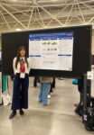 Lucia Herrero standing next to 2025 SRCD poster