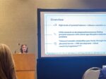 Madison Kelm standing behind podium presenting at 2025 SRCD